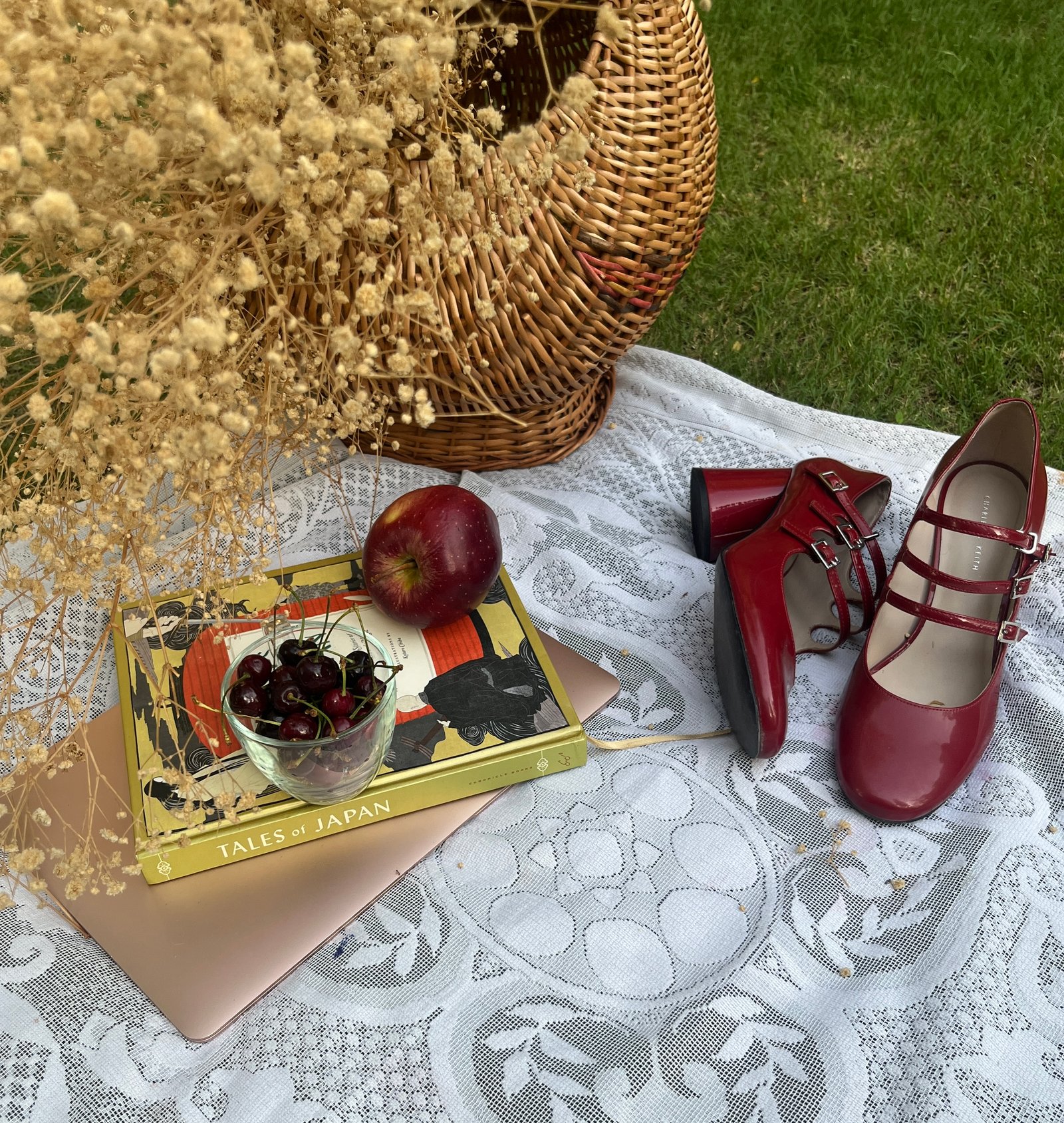Editorial styling setup with red shoes, lace, florals, and styling props